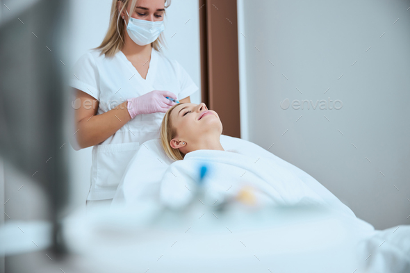 Pleased woman getting the serum scalp injection