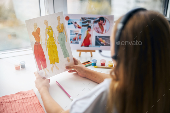 Girl In A Headset Holding Sketches In Her Hands Stock Photo By Iakobchuk