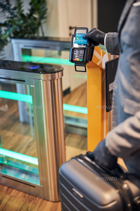 Businessman using his card on a gate scanning machine
