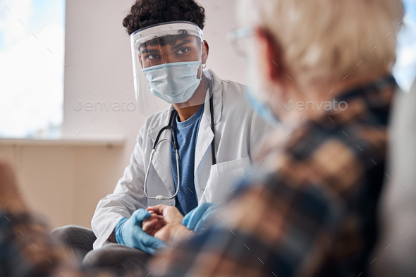 Young geriatric physician conducting a medical check-up - Stock Photo - Images