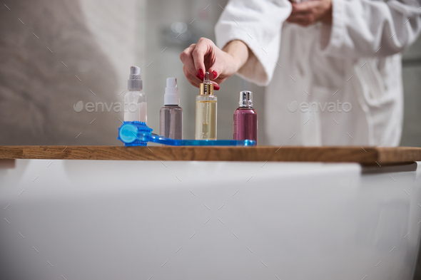 Cropped photo of lady arranging her cosmetics in the bathroom