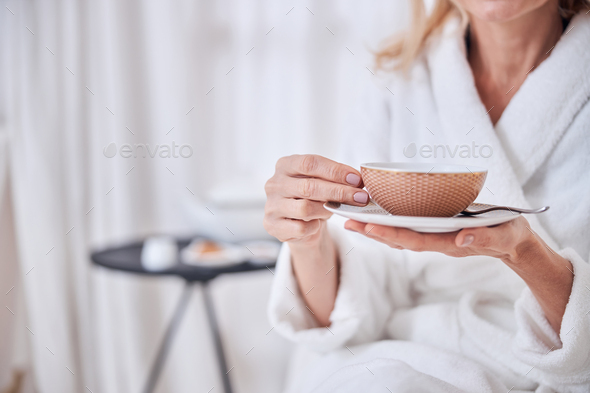 Female enjoying delicious cup of tea in spa resort hotel - Stock Photo - Images
