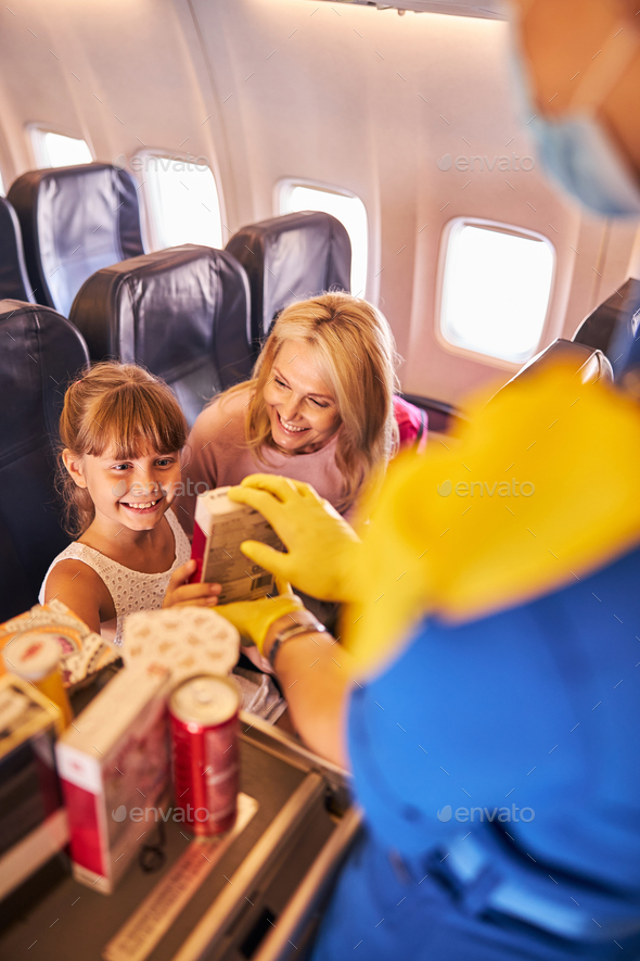 Cabin crew proposing some sweets to a girl