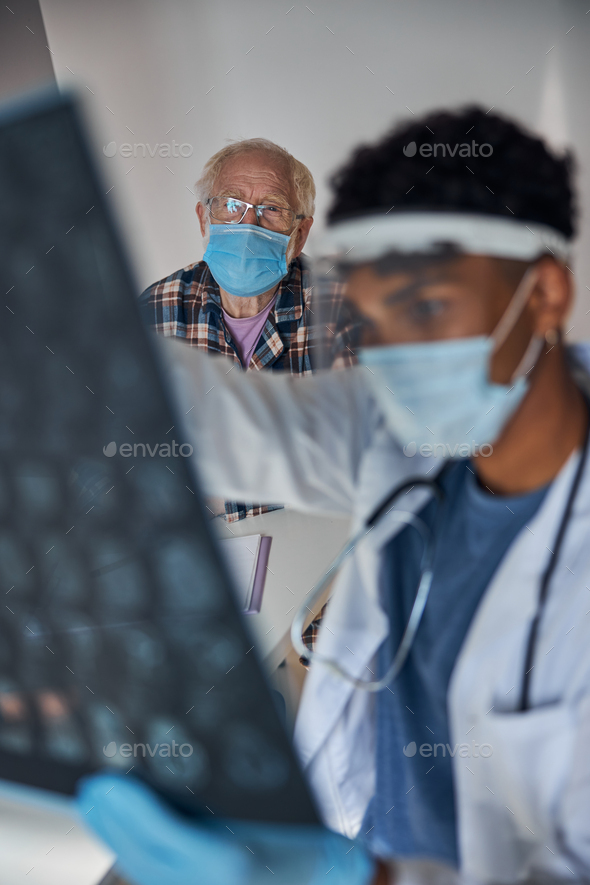 Concentrated young neurologist examining his patient MRI scans