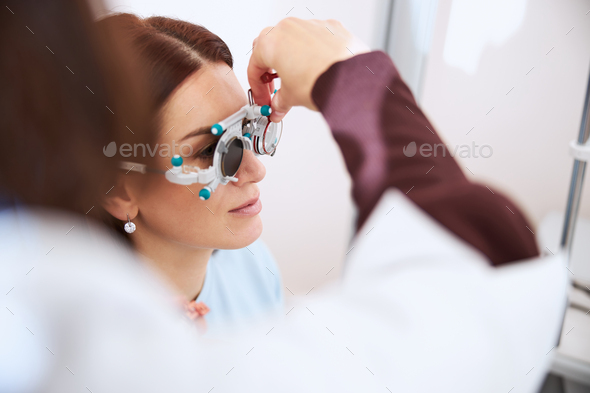 Medical person placing a lens inside a trial frame