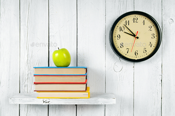 Watches, books and a green apple on wooden shelf. - Stock Photo - Images