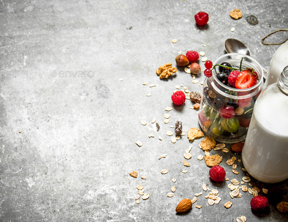 Fitness food. Muesli with berries, nuts and milk in bottles.