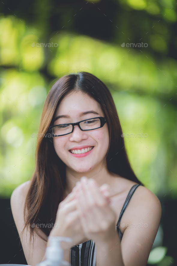 an asian young women using alcohol gel washing her hands to prevent ...