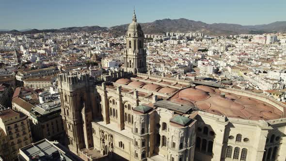 Magnificent sun-drenched Malaga Cathedral standing watch over city; aerial