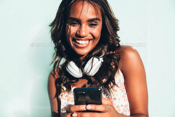 Portrait of beautiful happy black woman holding smartphone device ...