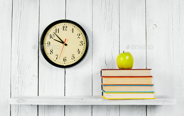 Watches, books and a green apple on wooden shelf. - Stock Photo - Images