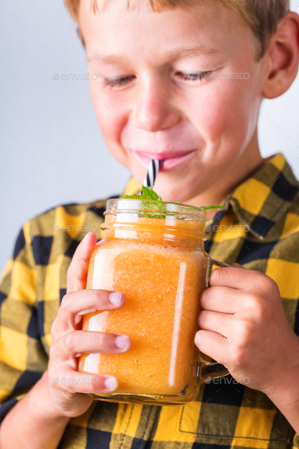 Happy boy drinking healthy smoothie with straw, enjoying and smiling Stock  Photo by antoninavlasova