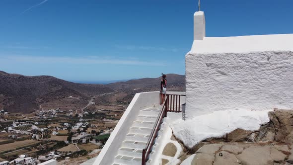 Woman making video on holiday, Chora village, Ios Island, Greece alt