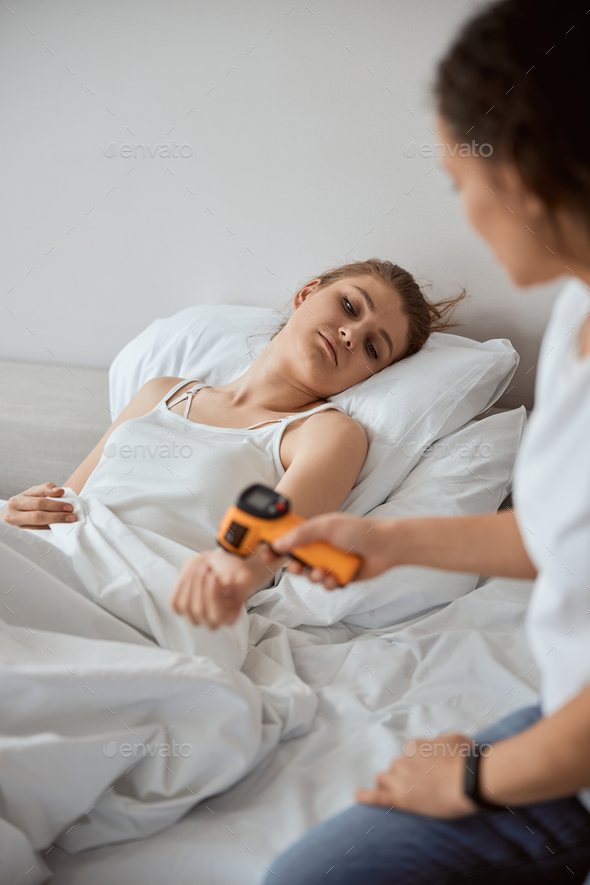 Frustrated woman feeling bad and measuring temperature