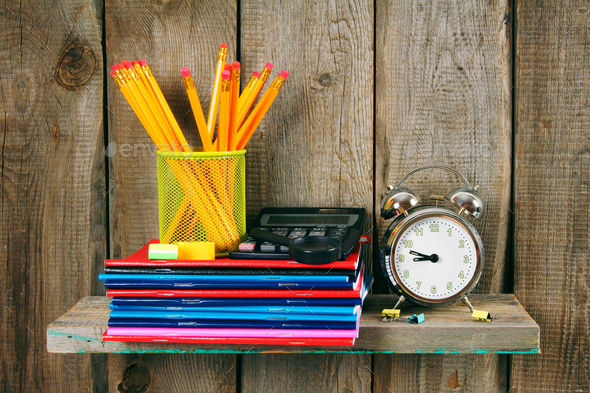 Writing-books, an alarm clock and school tools . - Stock Photo - Images