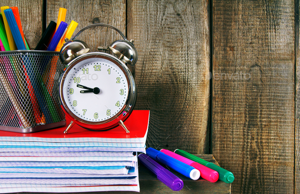Writing-books, an alarm clock and school tools. - Stock Photo - Images