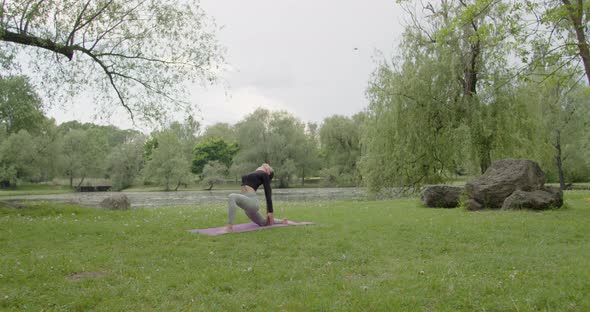 Fit Woman Doing Morning Yoga Exercises in the Park alt