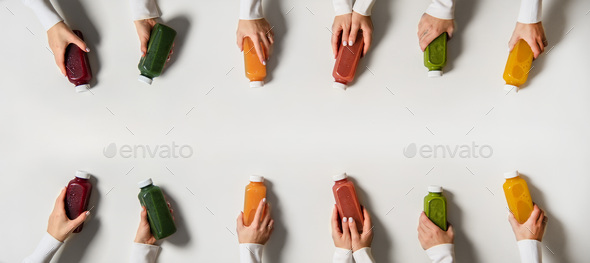Hands holding fresh natural organic juices in bottles, copy space - Stock Photo - Images