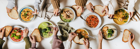 People eating various Autumn and Winter creamy vegan soups together - Stock Photo - Images