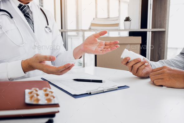 Confident female doctor reviews patient medical information and pointing to medical forms.