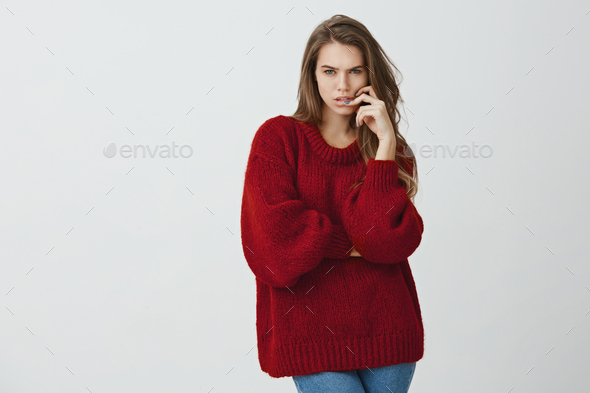 Girl trying to concentrate on math lesson. Portrait of beautiful feminine woman in red loose sweater