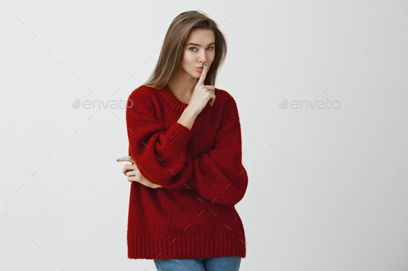 Girl asking friend to keep secret and told nobody. Playful flirty european woman in stylish loose