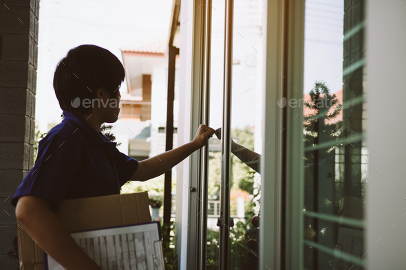 Young asian courier is using the hand of the knock at the door to deliver the goods.