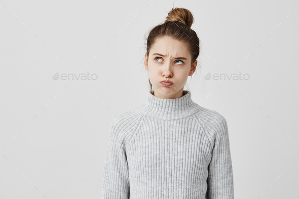 Infantile adult woman wearing casual with face upwards pretending to be offended. Pretty girl