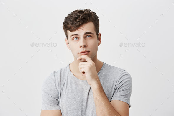 Hmm not bad. Concentrated thoughtful male student evaluating his chances to pass exam, keeps hand on