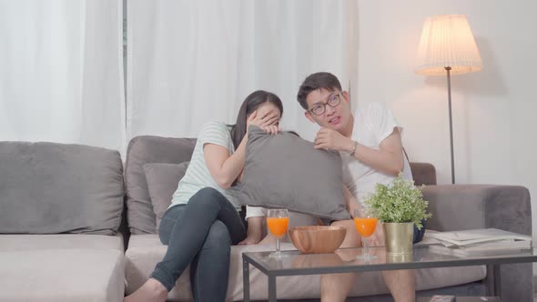 asian family watching scary movies at home