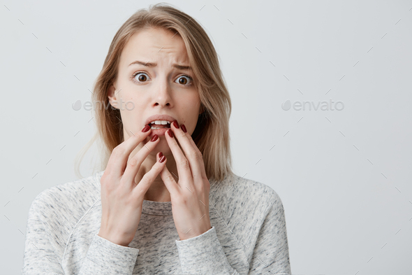 Surprised amazed attractive young blonde with dyed hair female wearingsweater having astonished face
