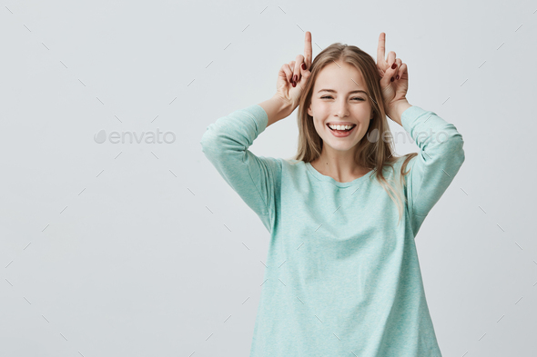 Human face expressions. Body language. Playful funny Caucasian woman with blonde dyed hair smiling