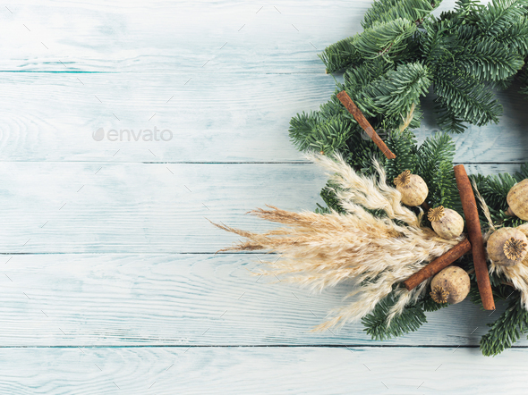 Christmas natural spruce wreath with dry decor, pampas reed and cinnamon on wooden background