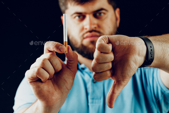 Man in blue short gesturing smoking is bad