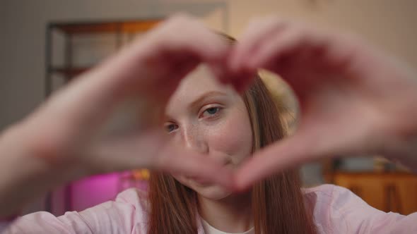 Teen Child Girl Kid Makes Symbol of Love Showing Heart Sign to Camera Express Romantic Feelings alt