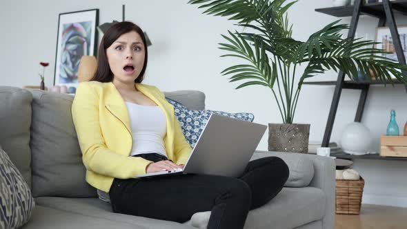 Woman in Shock Looking at Camera while Working on Laptop alt