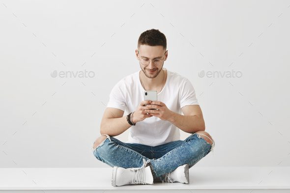 What an awesome app I downloaded. Studio shot of attractive young coworker sitting in trendy outfit - Stock Photo - Images