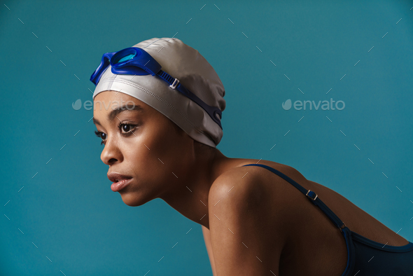 Young black swimmer in goggles posing and looking aside