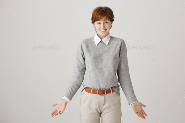 Woman did not have answer on question. Studio shot of attractive short-haired redhead female student