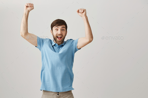 I won first prize in my life. Portrait of happy excited european guy jumping from joy, celebrating