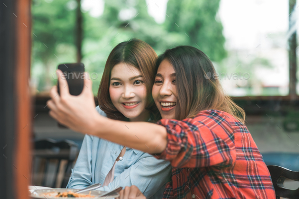 Asian women lesbian lgbt couple eating at restaurant or cafe. - Stock Photo - Images