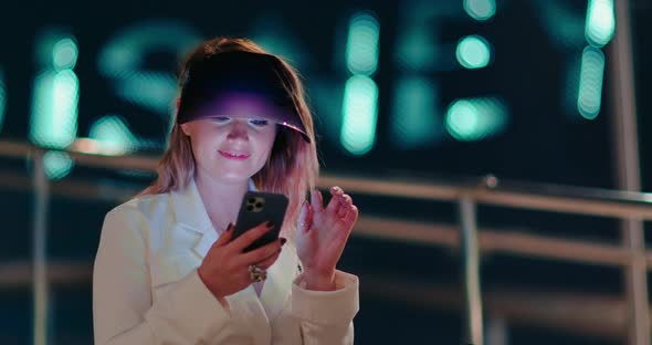 Attractive Woman Using Mobile Phone During Walk on Streets of Night Town alt