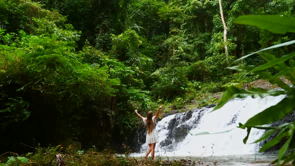 Traveler Woman Walking Front of Cascade Tropical Waterfall Enjoying Nature alt