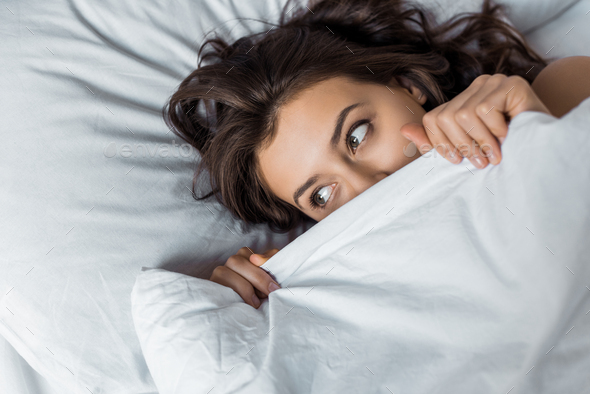 beautiful girl hiding under white blanket on bed Stock Photo by ...