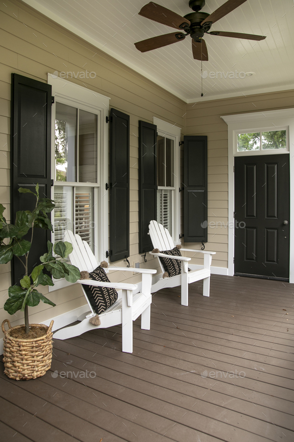Charleston style porch with chairs and entry door on southern home - Stock Photo - Images
