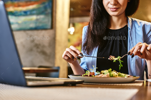 Snack time heals all wounds. Businesswoman having lunch in company's restaurant. Cozy interior