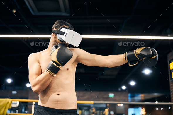 Sportsman doing shadow boxing in virtual reality headset - Stock Photo - Images
