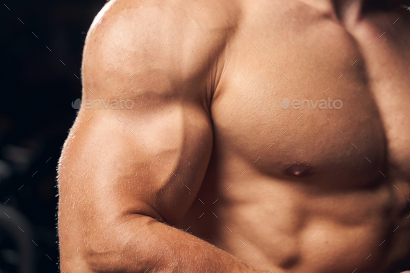 Strong man flexing his arm and chest muscles Stock Photo by Iakobchuk