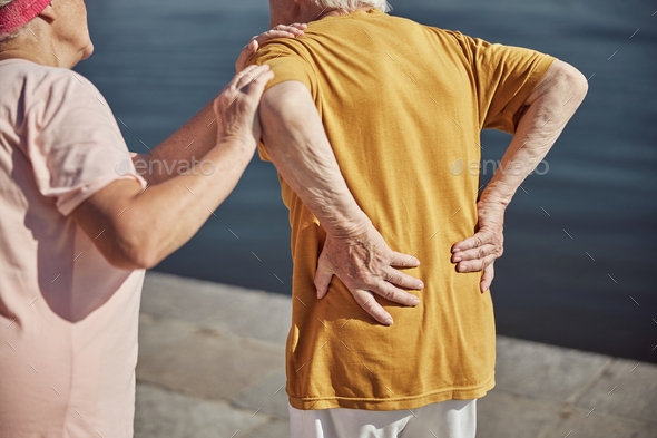 Caucasian male pensioner experiencing an acute backache - Stock Photo - Images