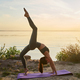 Beautiful young woman practicing yoga outdoors by the sea Stock Photo by  Iakobchuk